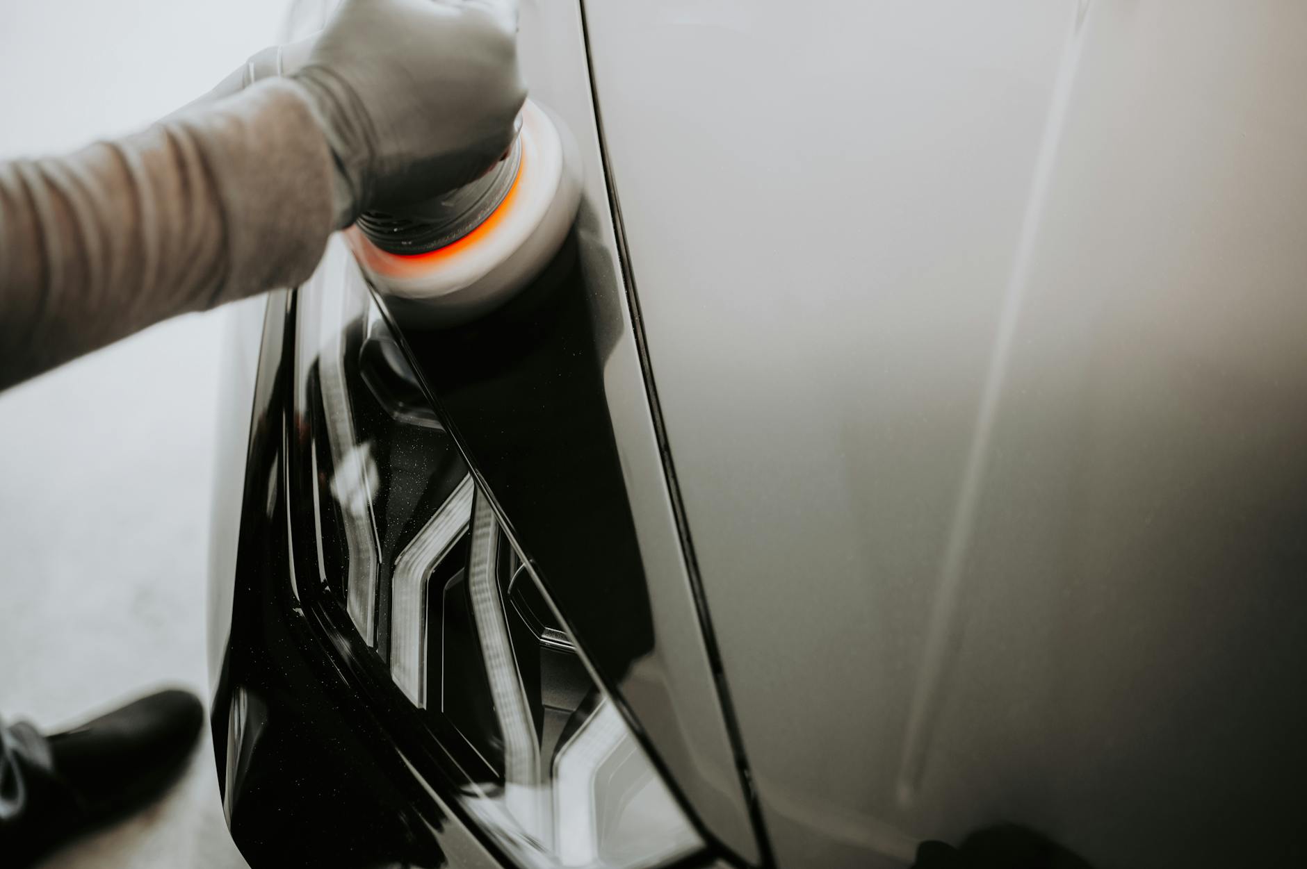 Schwarzes Auto wird von Hand poliert